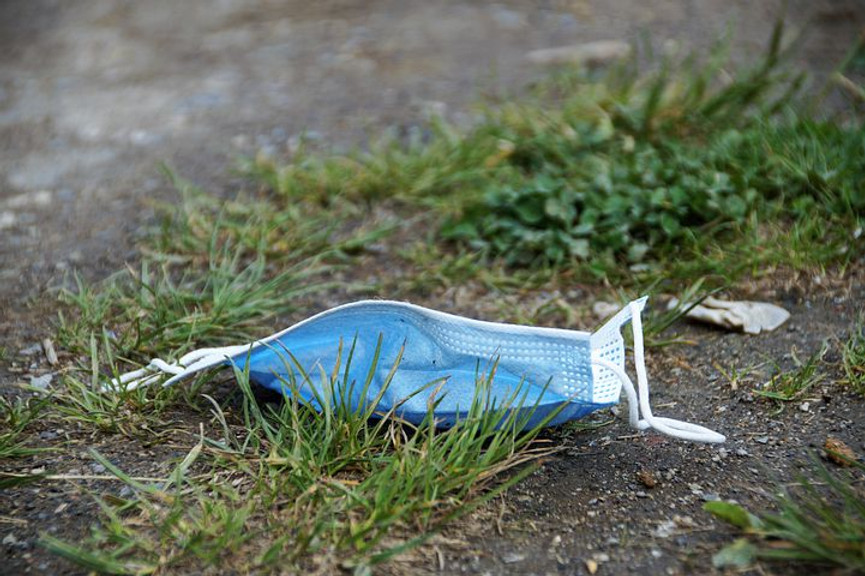 blue disposable face mask on the ground